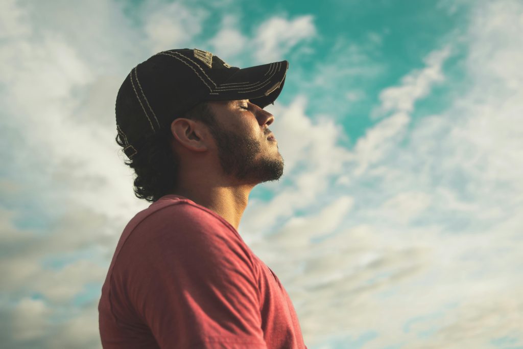 Man standing outside, mindfully taking in the sun