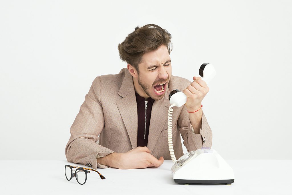 Man calling for crisis coaching, yelling at phone